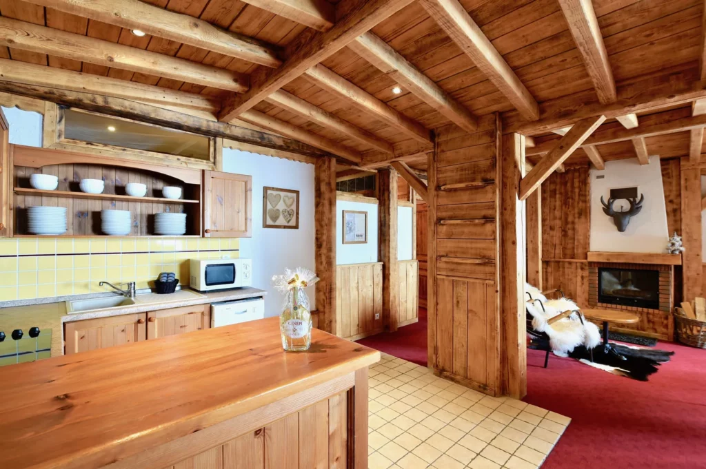 Vue d'ensemble cuisine ouverte et salon avec cheminée dans l'appartement standard plain-pied 6 personnes des Ancolies