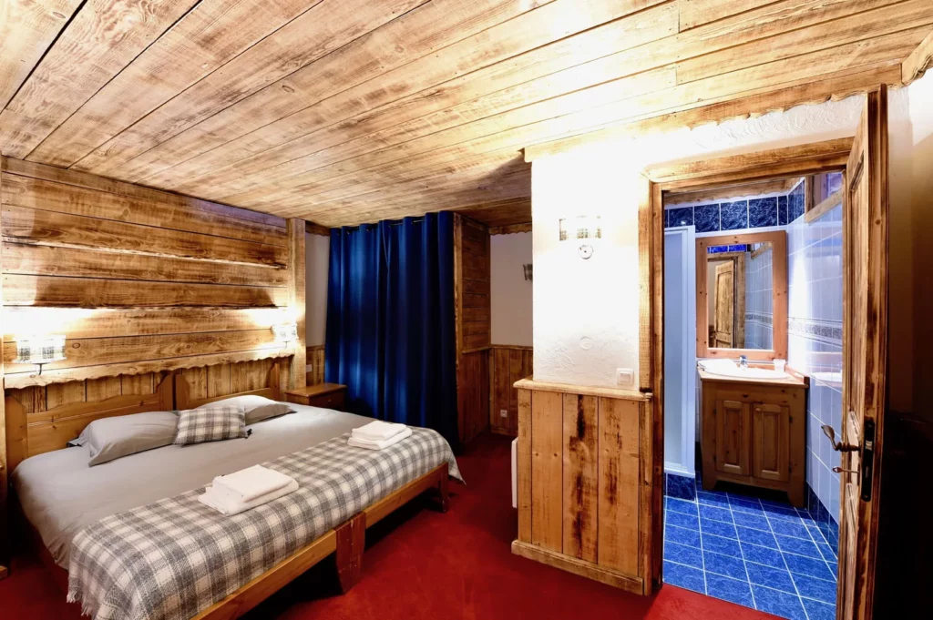 Chambre avec salle de bain attenante et carrelage bleu dans l'appartement standard plain-pied 6 personnes des Ancolies