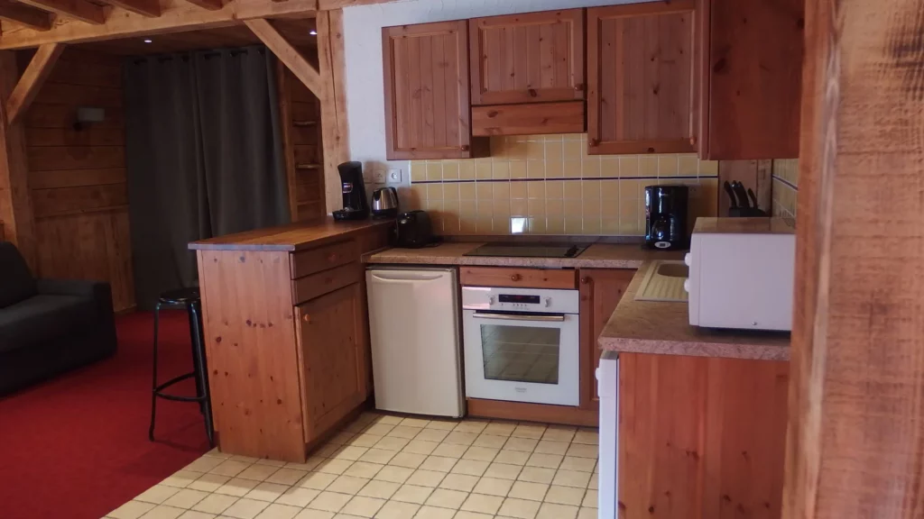 Cuisine équipée en bois avec four et micro-ondes dans l'appartement standard plain-pied 6 personnes des Ancolies
