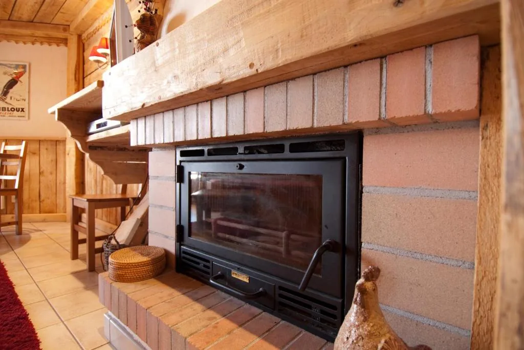 Insert cheminée en brique avec panier à bois dans l'appartement 8 personnes standard des Ancolies