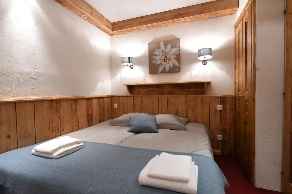 Chambre avec lit double et décoration edelweiss dans l'appartement 8 personnes standard des Ancolies