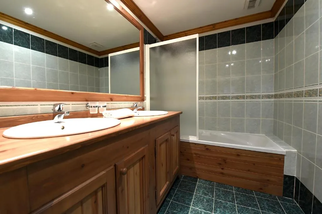 Salle de bain avec double vasque et baignoire dans l'appartement 8 personnes standard des Ancolies