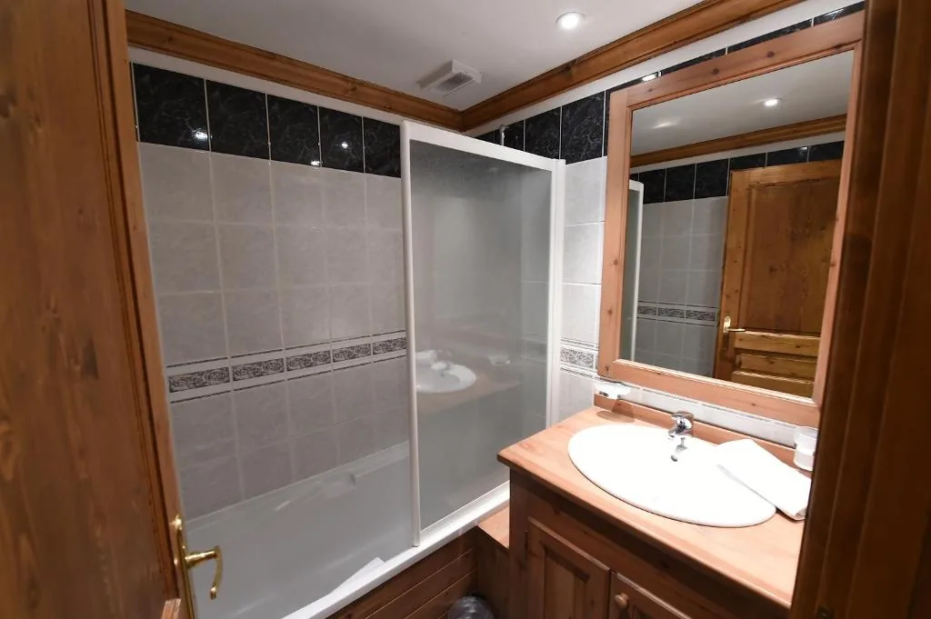 Salle de bain avec douche et vasque en bois dans l'appartement 8 personnes standard des Ancolies