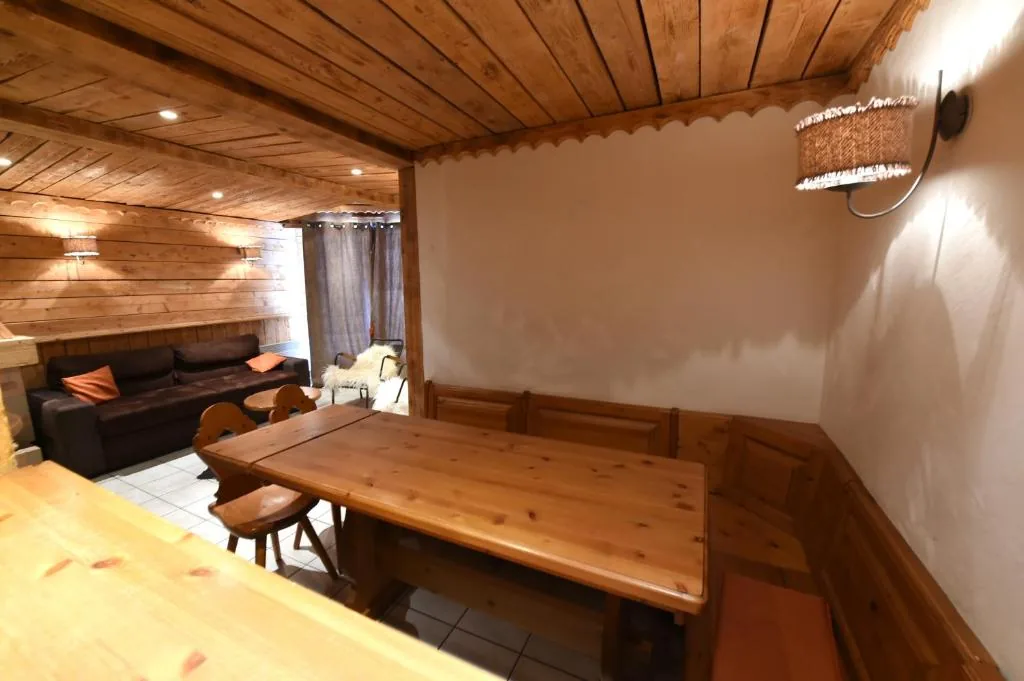Coin repas en bois massif avec banquette et salon dans l'appartement 8 personnes standard des Ancolies