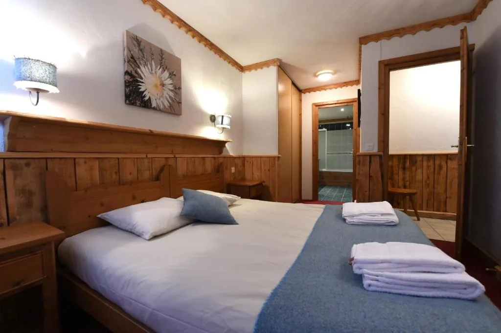 Chambre avec lit double et linge de lit bleu dans l'appartement 8 personnes standard des Ancolies