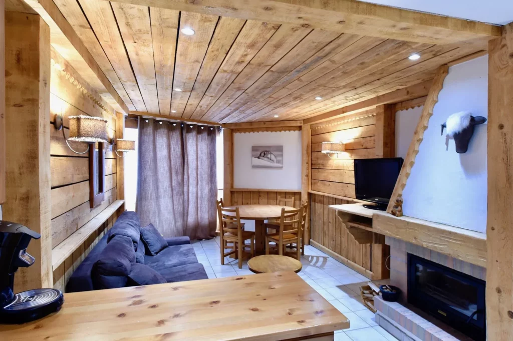 Vue d'ensemble du salon avec coin repas et télévision dans le duplex 6 personnes des Ancolies