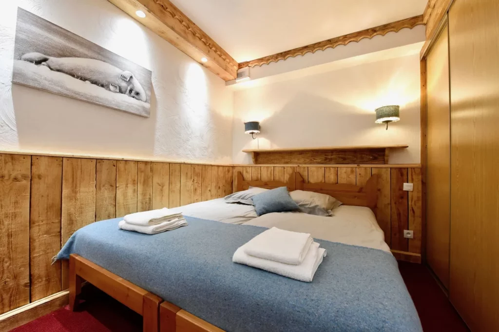 Chambre avec lit double et linge de lit bleu dans l'appartement duplex 6 personnes de la résidence Les Ancolies